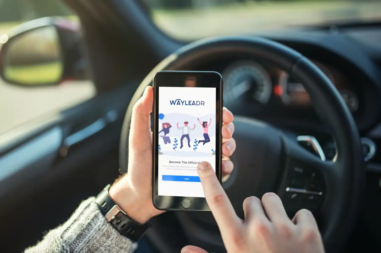 A person sitting in their car uses the Wayleadr app on their smartphone, finger poised to log in and manage visitor parking efficiently.