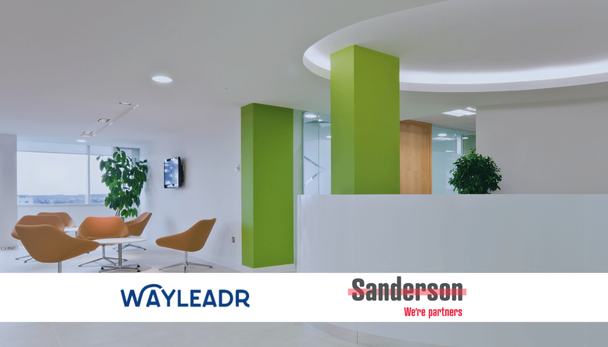 Modern office lobby with green columns, white reception desk, and orange seating area. Two logos on the image: WAYLEADR on the left and Sanderson on the right, with the tagline "We're partners." The space also features commercial parking solutions by WAYLEADR for a seamless visitor parking experience.