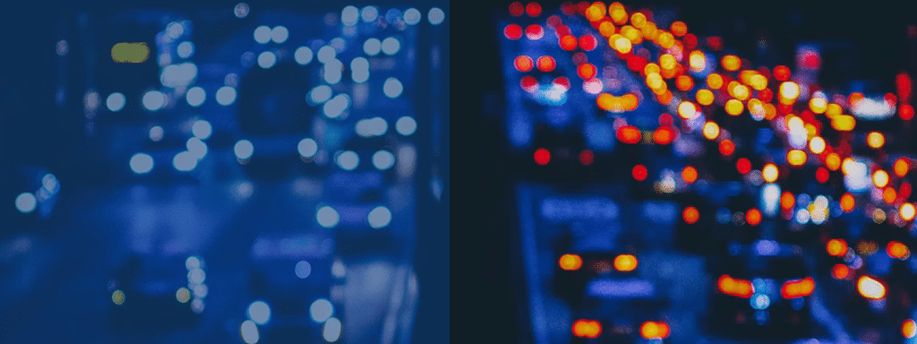 Blurred image of heavy traffic on a road. The left side appears in a blue hue, while the right side has a red and orange hue, resembling the chaos of inefficient parking lot management.