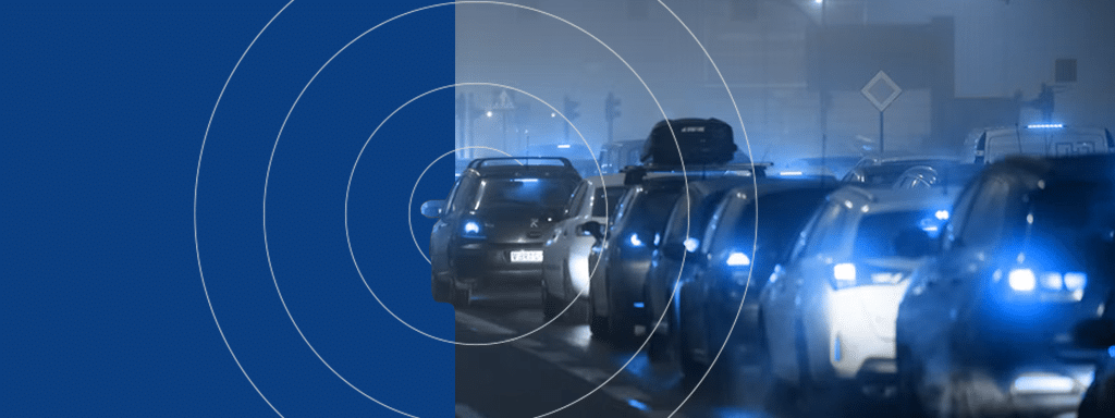 A line of cars with headlights on are seen driving in a foggy environment, evoking the eerie stillness often associated with commercial parking lots, while concentric circles overlay the left side of the image.