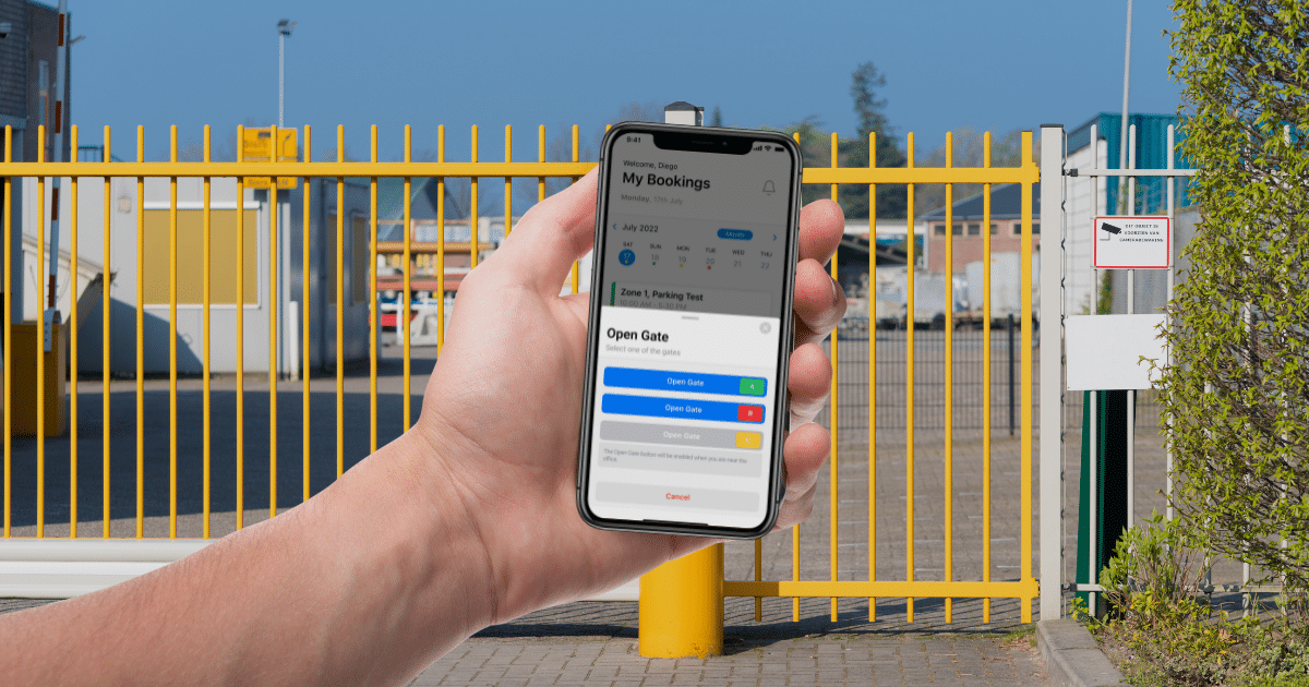 A person holding a smartphone showing a gate control app in front of a yellow industrial gate, showcasing innovative parking lot management.