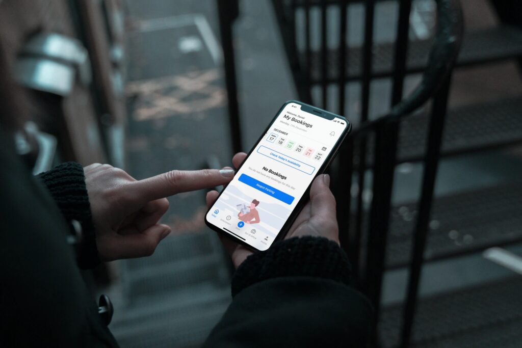 A person navigates a health tracking app on their smartphone while standing on a staircase, thinking about how Wayleadr's parking management system could streamline their office parking lot.