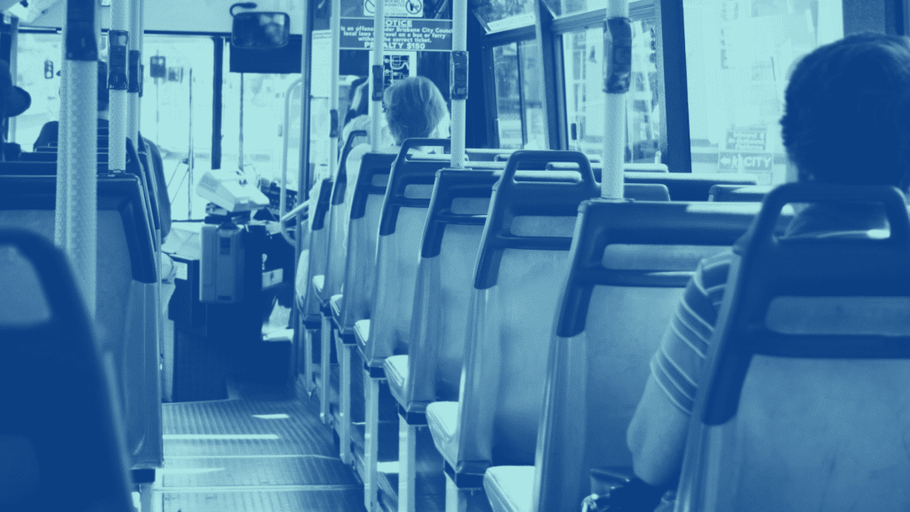 Interior of a bus with several passengers seated facing forward. The focus is on the aisle and the back of the seats, reflecting a serene and orderly atmosphere akin to well-run parking management.