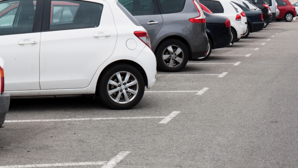 Several parked cars in designated spaces in a parking lot, with some empty spaces visible, highlight how efficient wayleadr's commercial parking lot systems are.