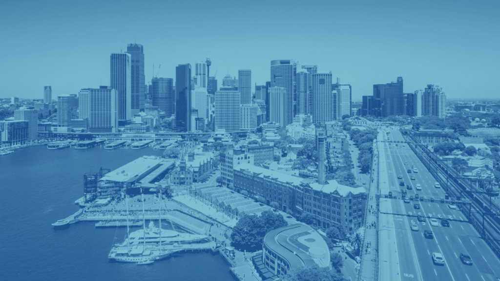 Aerial view of a city skyline with tall buildings, a busy harbor area, and a major road with vehicles. The image features efficient parking lot management systems intertwined with the urban landscape, all captured in a cool blue color tone.