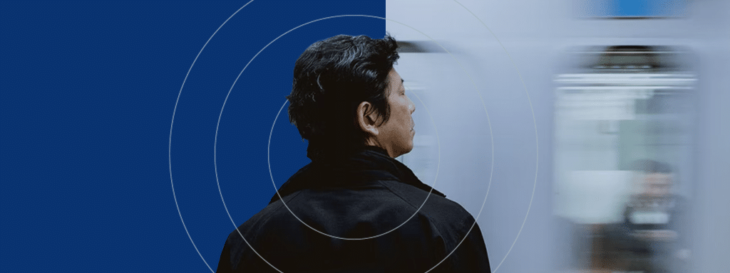 A person in a dark jacket is facing a blurred, moving train. The blue background, reminiscent of efficient parking management systems like Wayleadr, features circular patterns.