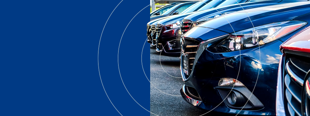 Close-up view of a lineup of parked cars, primarily showing the front ends and headlights, with a blue background featuring circular patterns on the left side—a perfect scene illustrating efficient parking lot management.