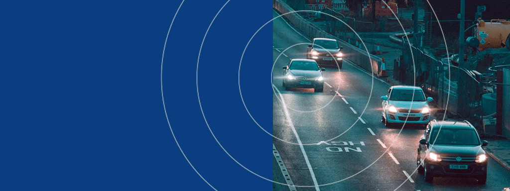 Several cars driving at night on a wet road with visible traffic lights and construction barriers on the right, accompanied by graphic radar-like circles on the left side, creating an atmosphere of intricate parking management.