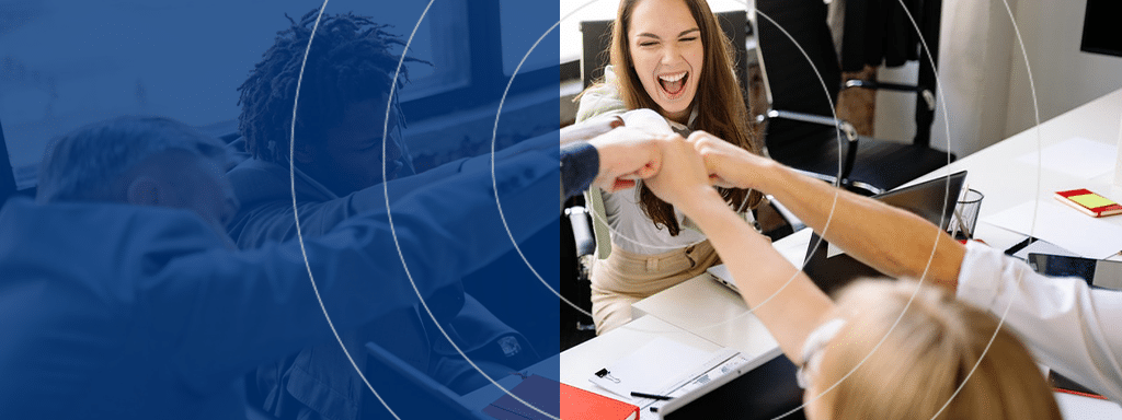 A group of people seated at a table, smiling, and performing a group fist bump in an office setting, with a blue design overlay on the left side of the image. The team is celebrating their latest success in commercial parking management using Wayleadr's innovative solutions.