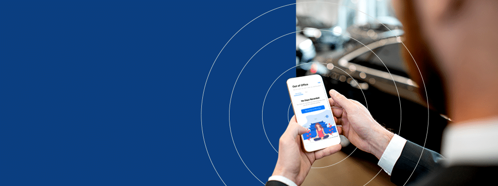 A person in a suit holds a smartphone displaying the Wayleadr app screen with text and login fields, against a blurry indoor background of a car, providing seamless parking management.