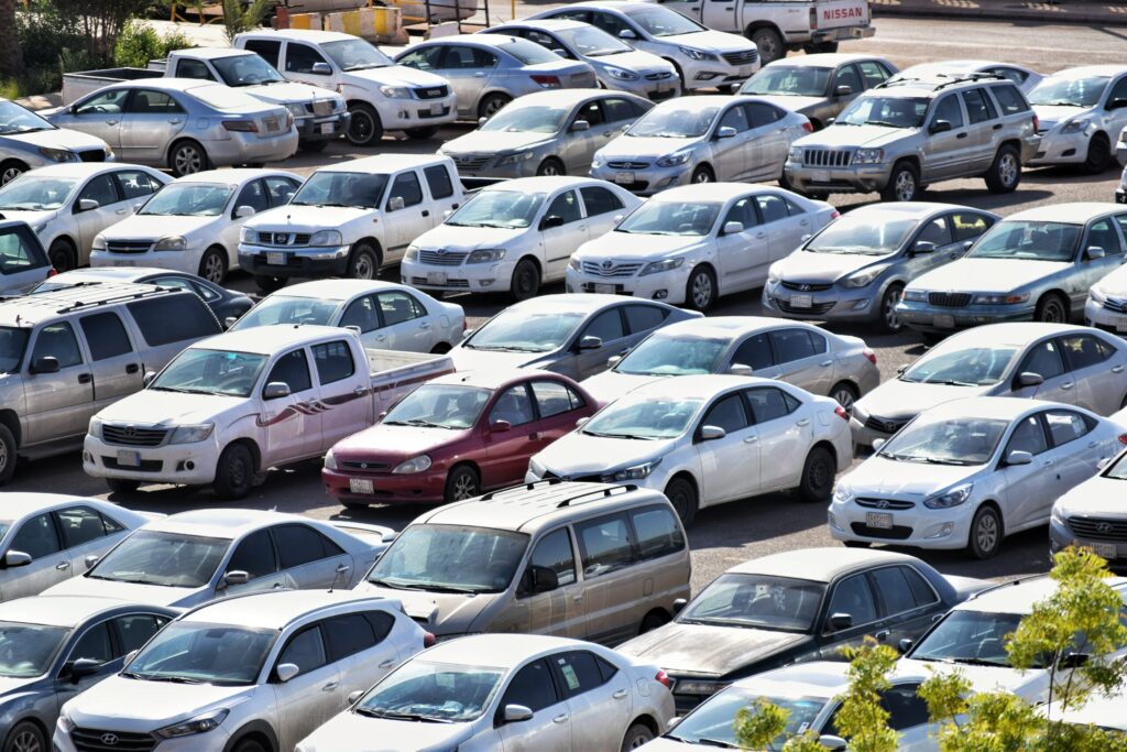 A crowded parking lot filled with various models of cars, mostly white and silver, viewed from above. The commercial parking area efficiently handles visitor parking with the help of Wayleadr technology.