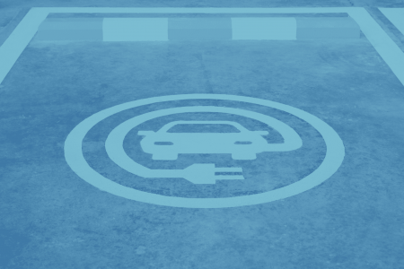 A parking spot with a painted symbol indicating it's designated for electric vehicle charging, ideal for commercial parking areas.