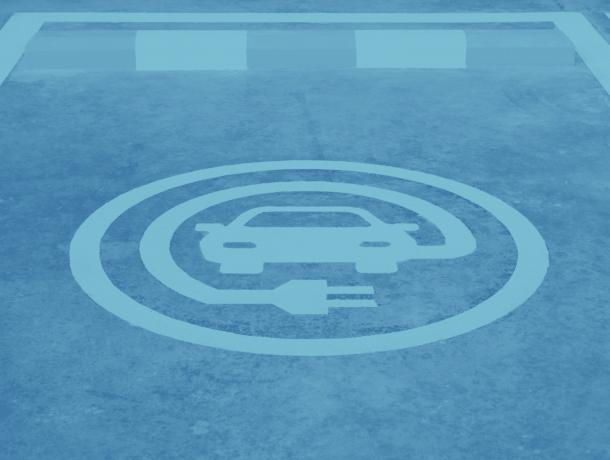 A parking spot with a painted symbol indicating it's designated for electric vehicle charging, ideal for commercial parking areas.